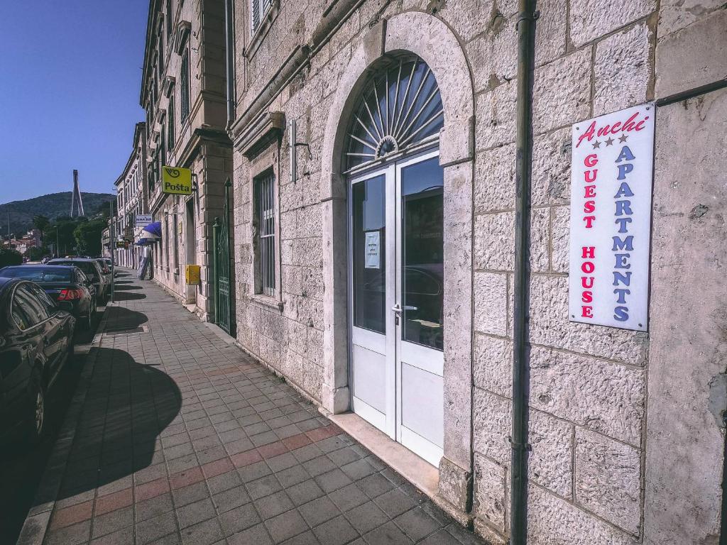un edificio con una porta bianca e un cartello sopra di Anchi Guesthouse a Dubrovnik
