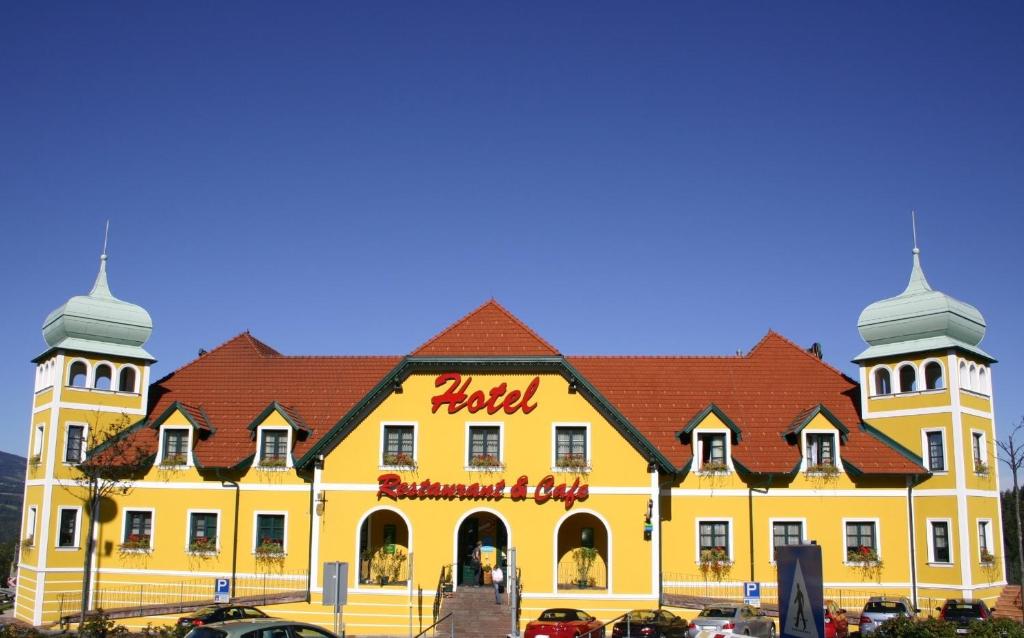 a large yellow building with a hotel sign on it at Autobahnrestaurant & Motorhotel Zöbern in Zöbern