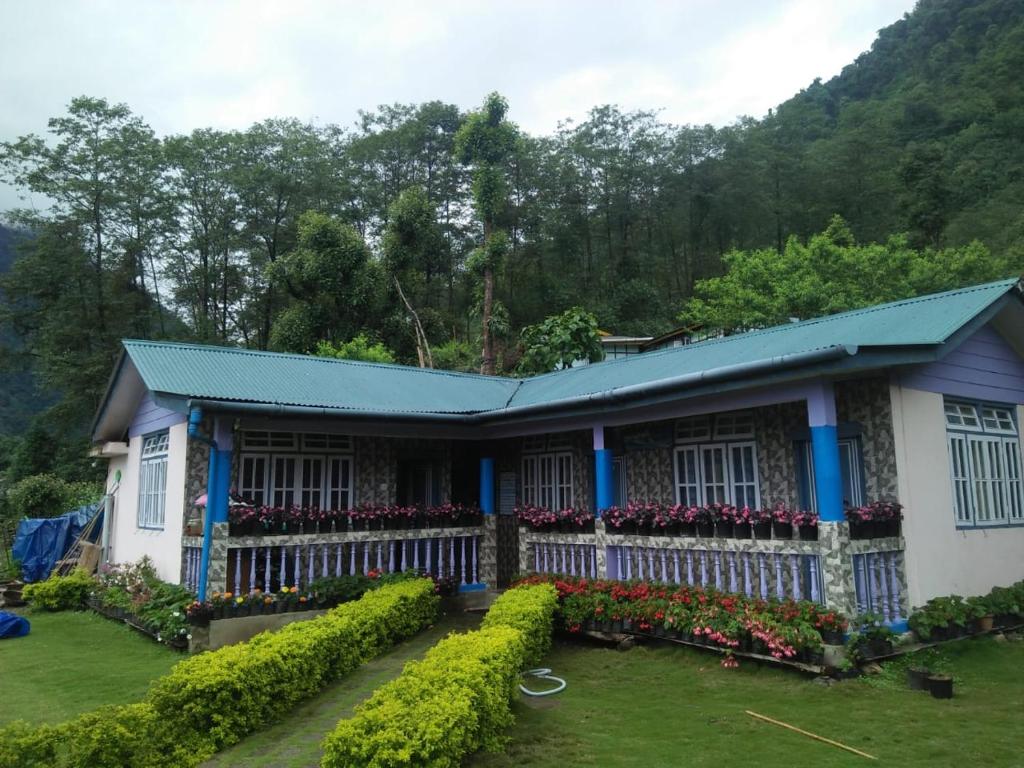 a house with a garden in front of it at Vamoose Chungdah Homestay in Pemayangtse
