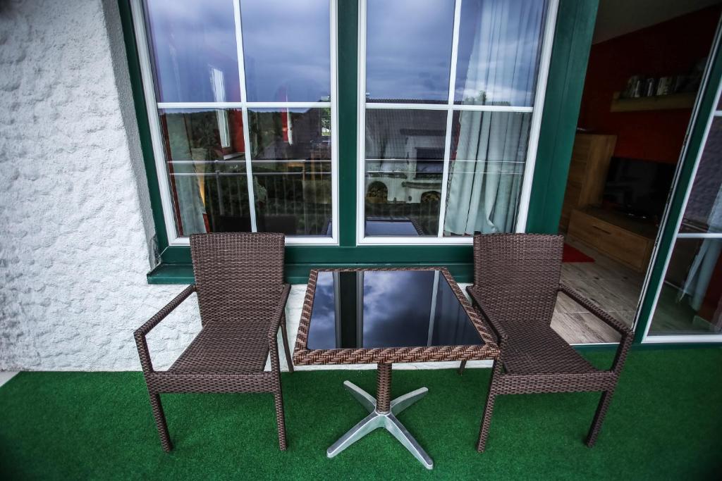 2 Stühle und ein Tisch vor einem Fenster in der Unterkunft Landhaus Peer Waldviertel in Litschau