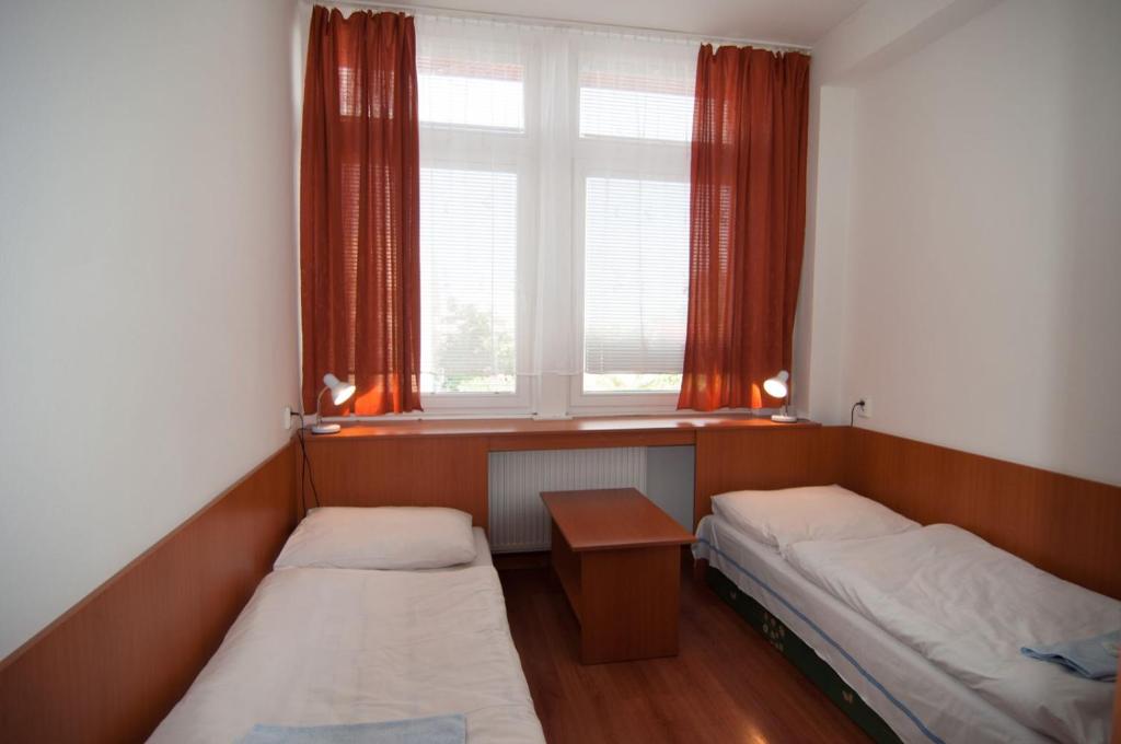 a small room with two beds and a window at Hotel Avion in Bratislava