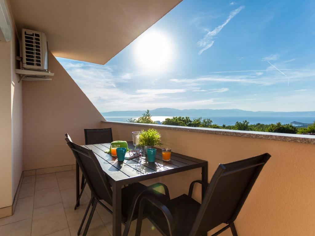 una mesa y sillas en un balcón con vistas en Lavish Apartment in Omi alj with Rooftop Terrace en Omišalj