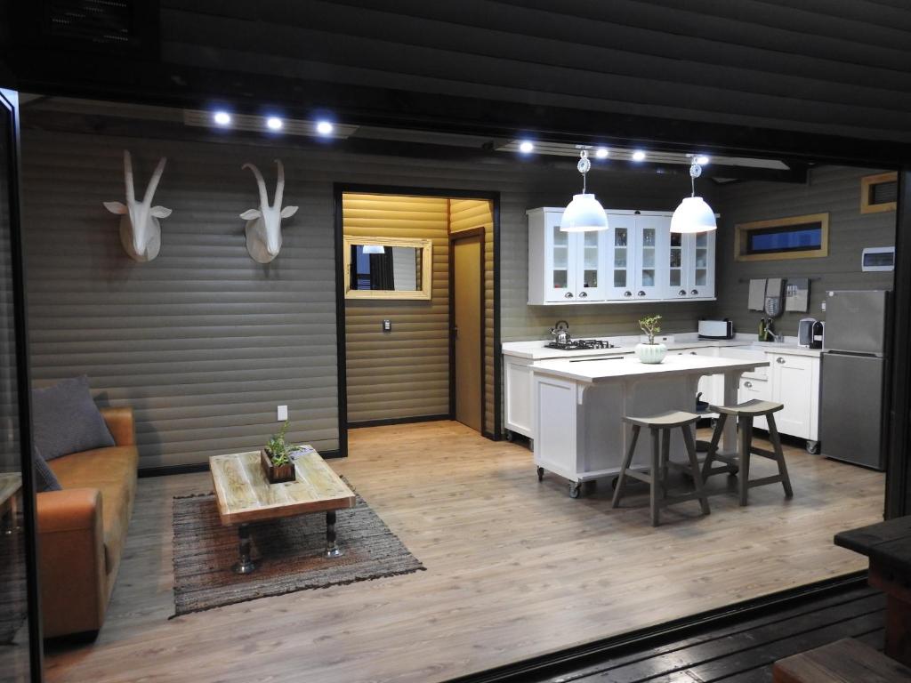 a kitchen and living room with a table and a counter at Timmerstuga in Malelane