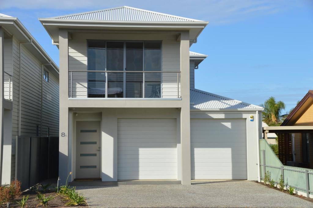 a house with two garage doors and a balcony at Western Breeze in Port Willunga