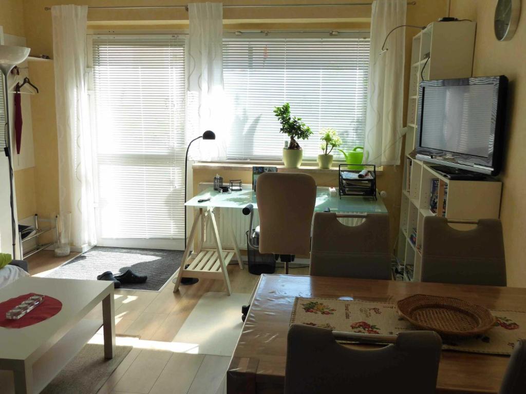 a living room with a table and a desk with a television at Ferienwohnung Winter in Lutherstadt Wittenberg