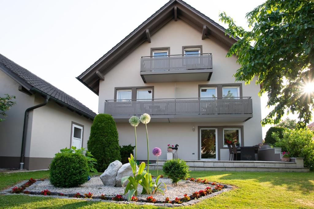 a house with a balcony and a yard at Appartementhaus Badria in Bad Füssing