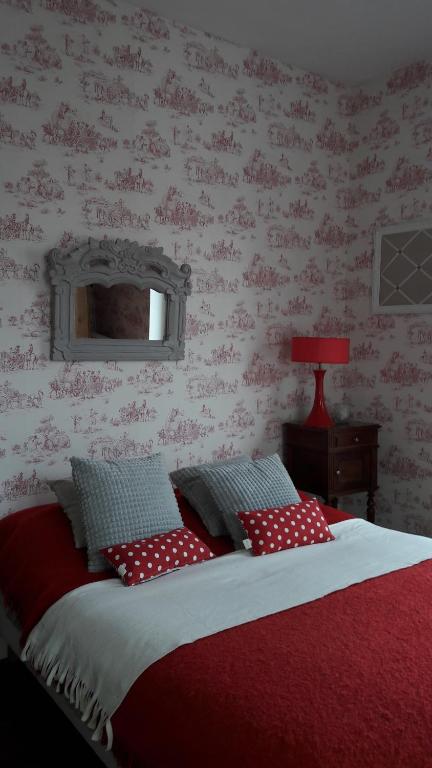 ルマンにあるCecileのベッドルーム1室(赤と白の枕が備わるベッド1台付)