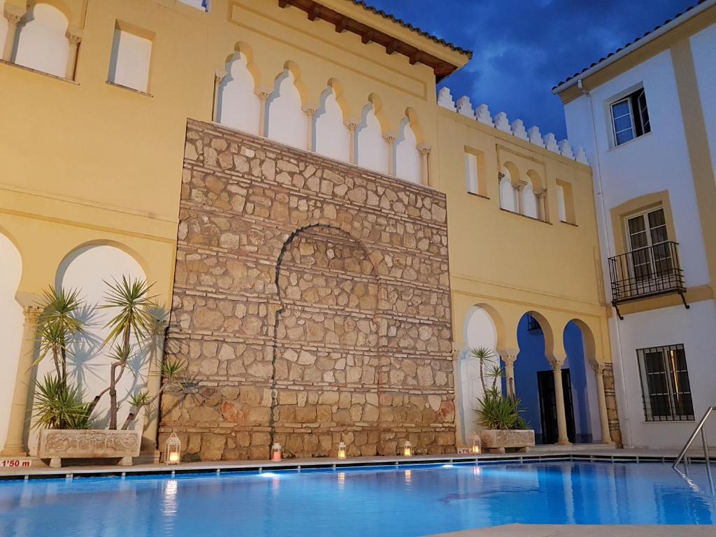 a swimming pool in front of a building at Hotel Macià Alfaros in Córdoba