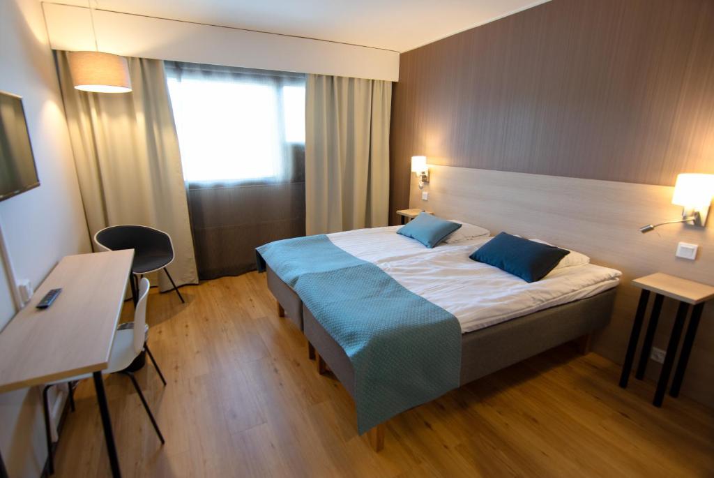Habitación de hotel con cama con almohadas azules en Hotel Kivitasku, en Kaarina