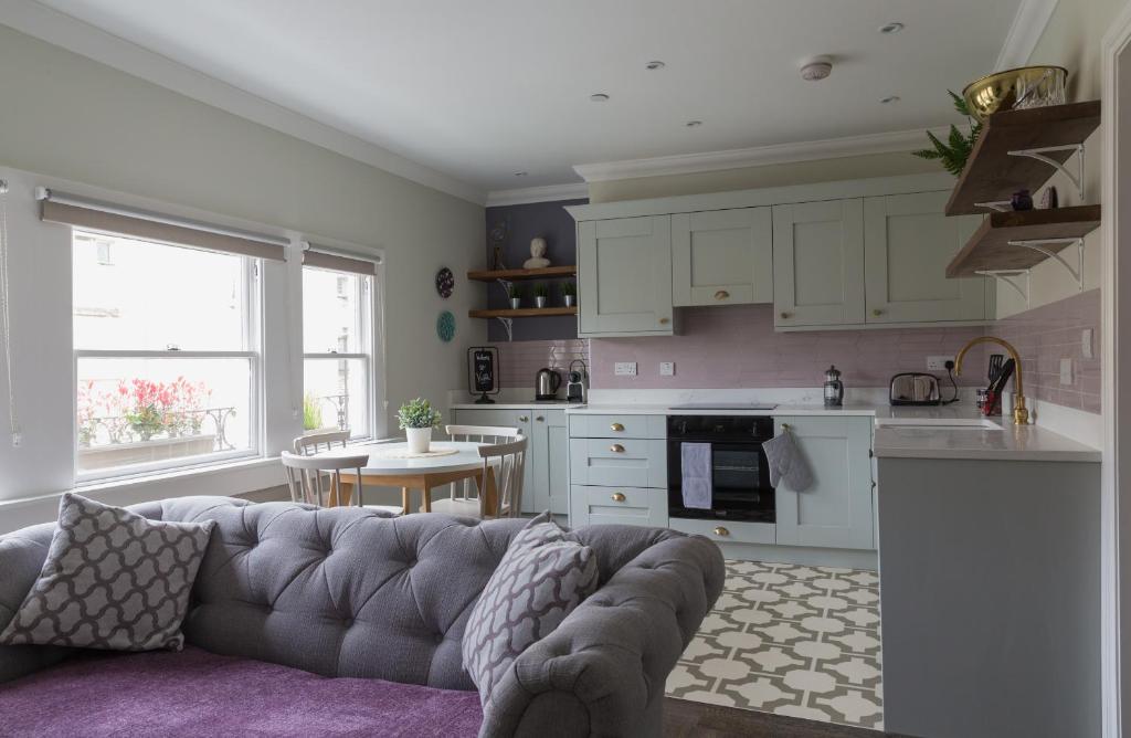 a living room with a couch and a kitchen at Vesta Central Bath Apartment in Bath