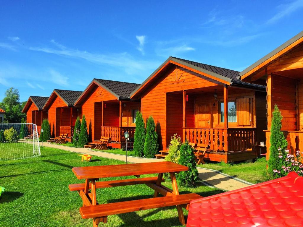 a row of lodges with a bench in the yard at ALBATROS Wicie in Wicie