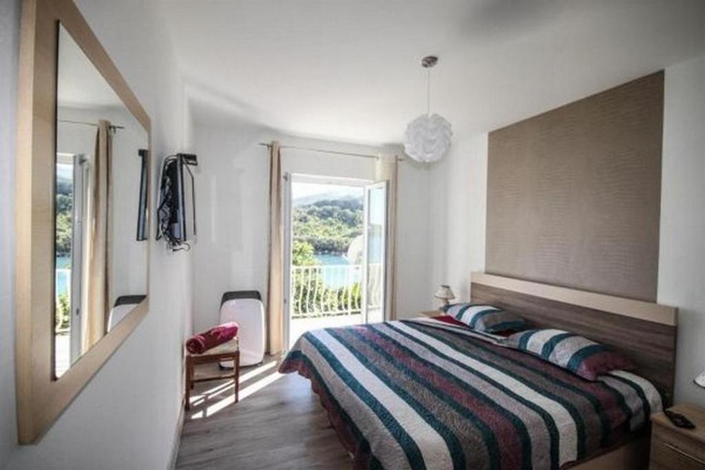 a bedroom with a bed and a large window at Villa Marija - Sea View Rooms in Molunat