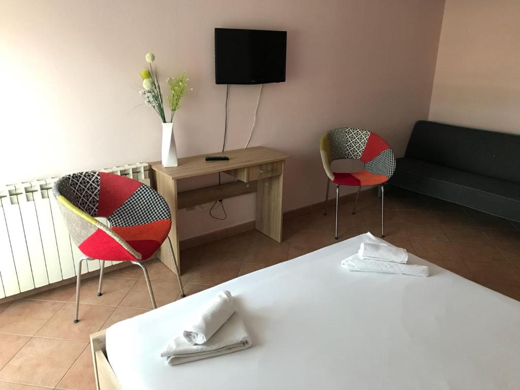 una camera con due sedie, un letto e una TV di Guest House Ivo a Spalato (Split)