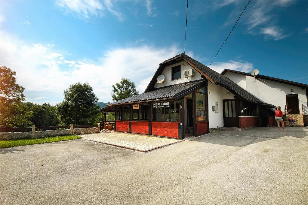 a woman standing in front of a building at Guest House Spoljaric Sasa in Rastovača