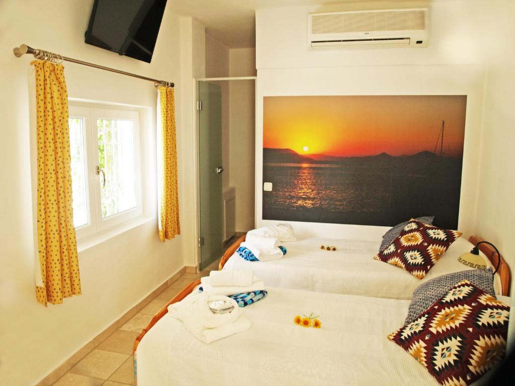 two beds in a room with a picture on the wall at Perikleshills in Thermisia