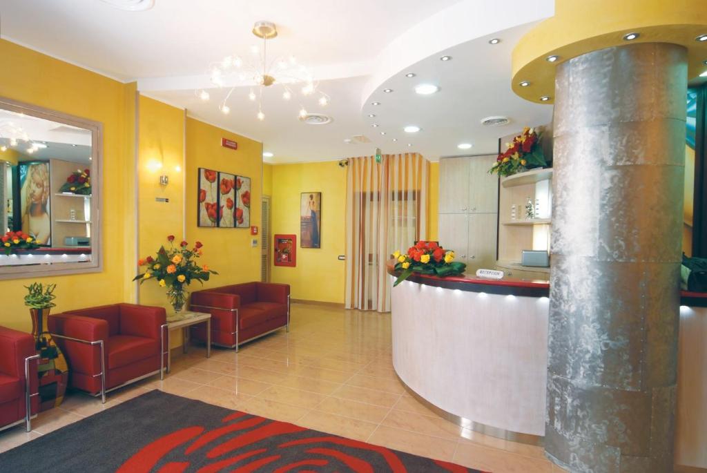 a lobby with a bar in a hospital with red chairs at Hotel Cristal Eboli in Eboli