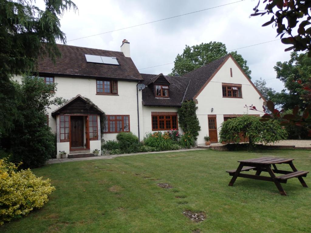 a house with a picnic table in the yard at Larkrise Cottage Bed And Breakfast in Stratford-upon-Avon