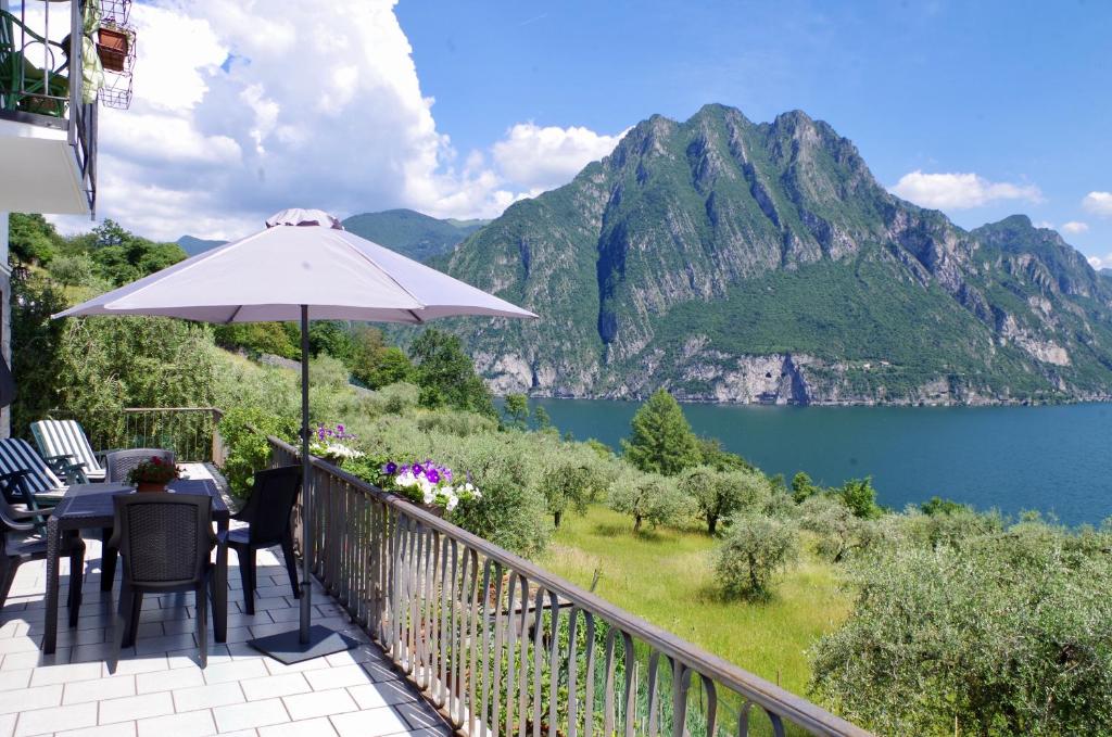 a balcony with an umbrella and a view of a lake at Casa Emilia in Riva di Solto