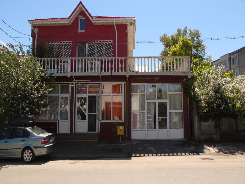 una casa roja con balcón en la parte superior. en Hotel Continental, en Roşiori de Vede