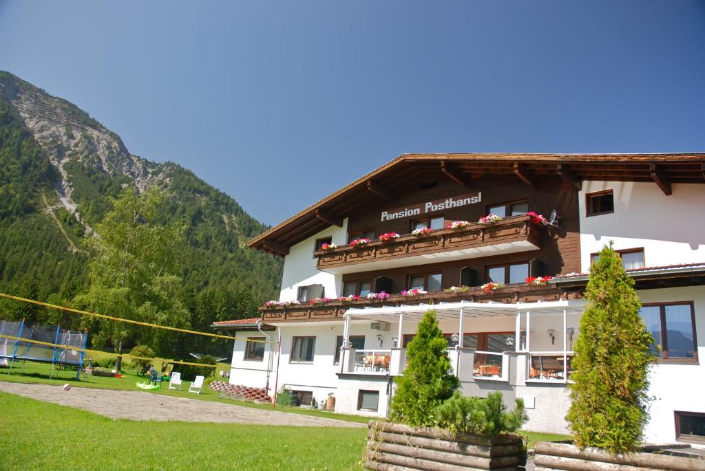 um hotel nas montanhas com montanhas ao fundo em Pension Posthansl em Heiterwang