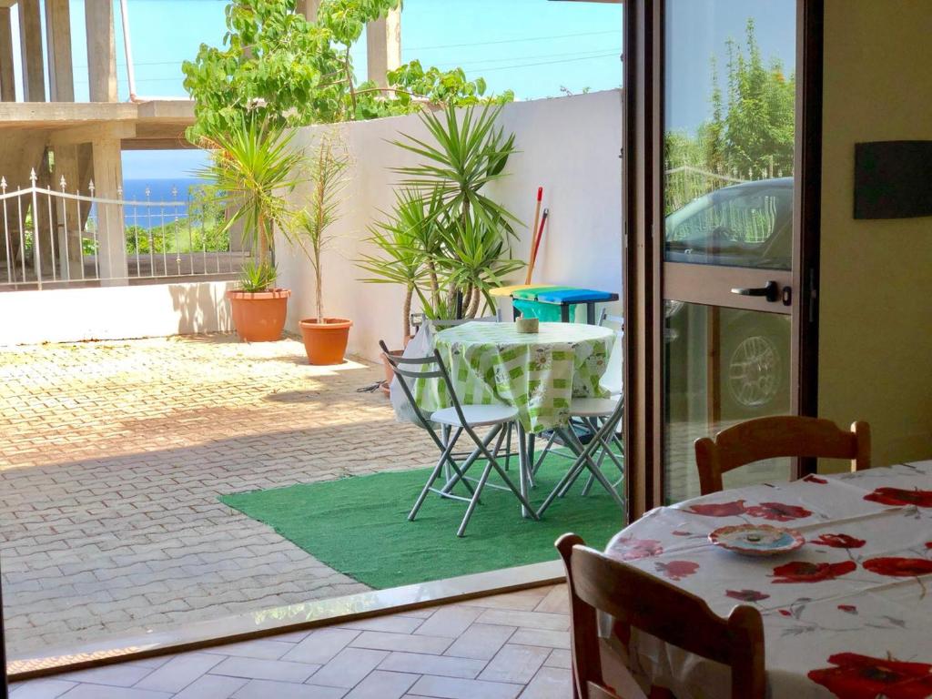 Habitación con mesa, sillas y patio. en Summer Loft, en Tropea