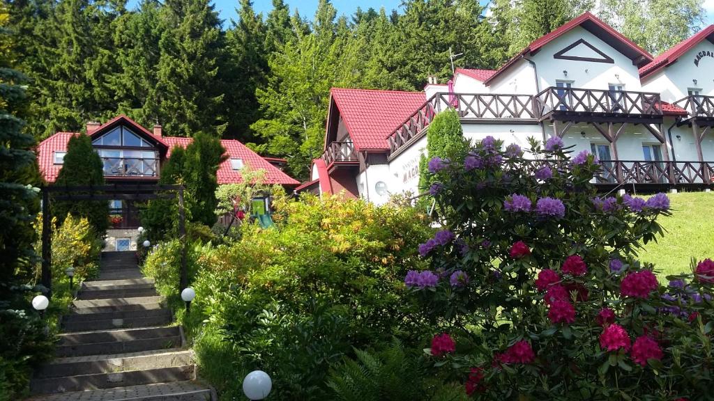 シュクラルスカ・ポレンバにあるPensjonat Magdalenaの花の家の前の庭