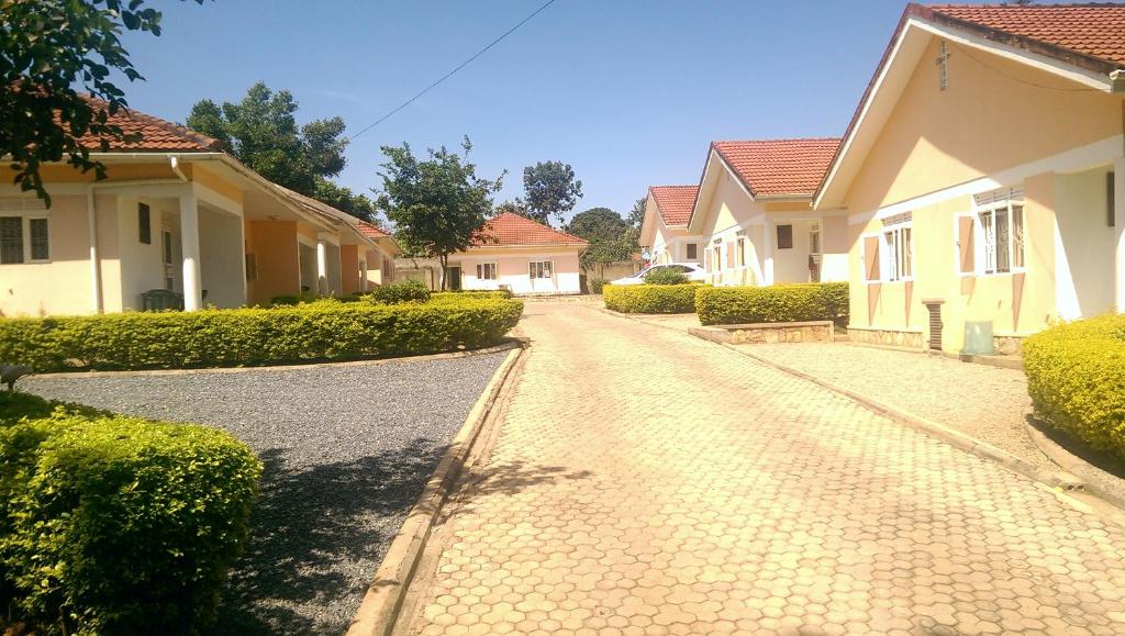 uma rua de calçada num bairro residencial com casas em Corinya Serviced Apartments em Entebbe