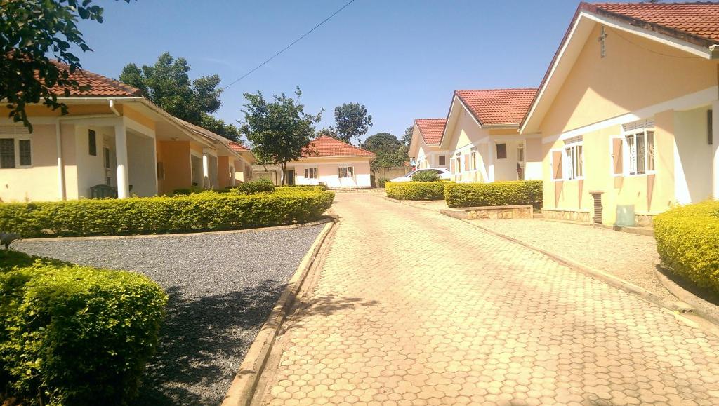 a cobblestone street in a residential neighborhood with houses at Corinya Serviced Apartments in Entebbe