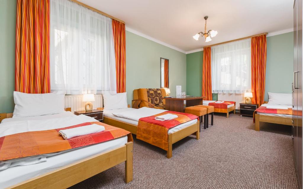 a hotel room with two beds and a desk at Hostel Biały Dom in Krakow