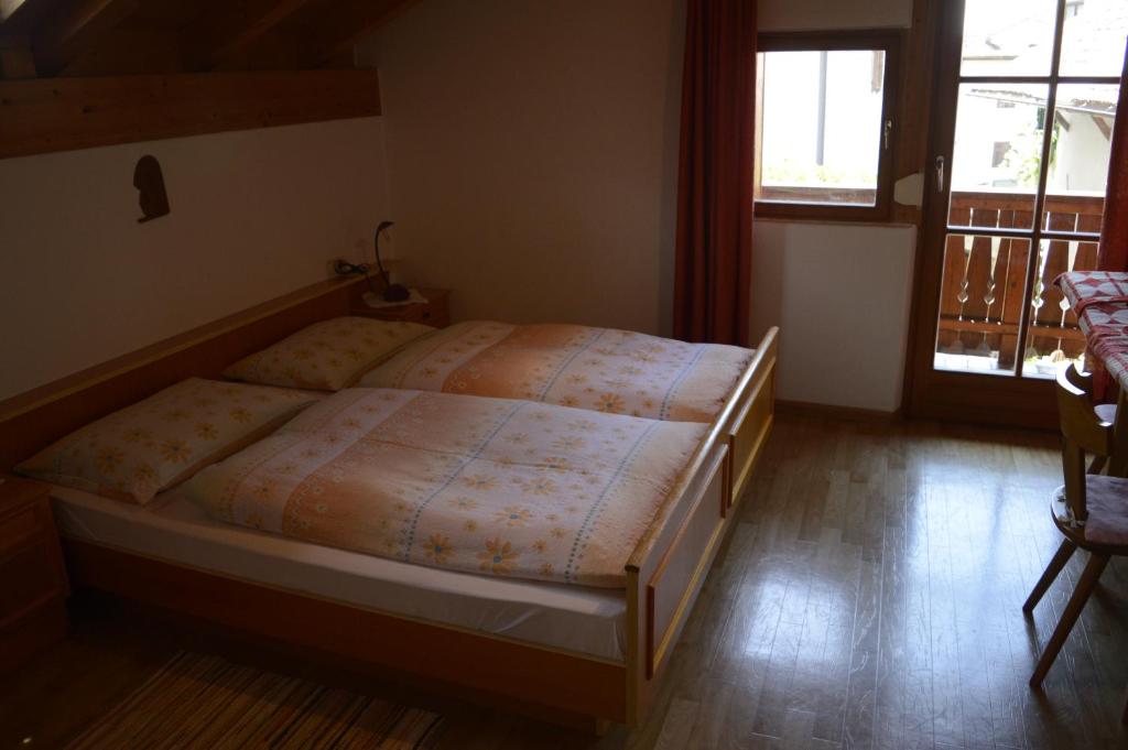 1 dormitorio con 1 cama y suelo de madera en Mansarde en Cornaiano