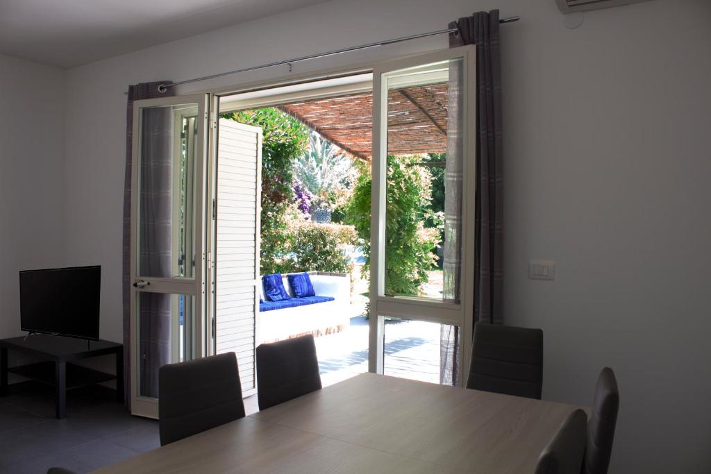 a dining room with a table and a sliding glass door at The Green Seaside in Fondachello
