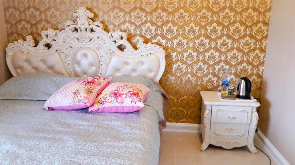 una camera da letto con un letto bianco e cuscini rosa di J-Koayai for 3 person & The Ribman a Nong Nam Daeng