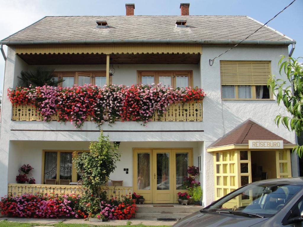 una casa con flores a un lado. en Gerania ház, en Vonyarcvashegy