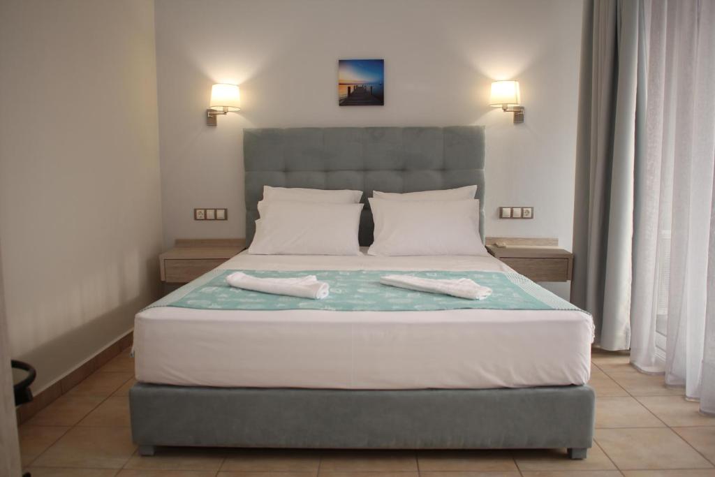 een slaapkamer met een bed met twee handdoeken erop bij Studios Kostis in Limenaria