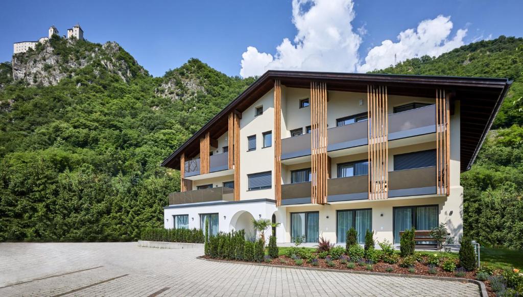 un edificio con montagne sullo sfondo di Residence Laitacherhof - Modern eingerichtete Apartments in der Nähe vom Zentrum von Klausen mit Aussenpool und Sauna a Chiusa