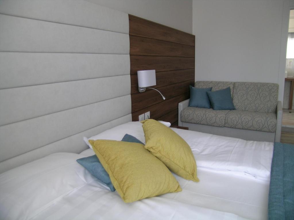 a bedroom with a bed with yellow and blue pillows at Hotel Belvedere in Venice-Lido