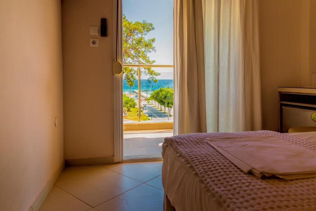 a bedroom with a bed and a view of the ocean at LE MONDE Seaview Suites in Nea Kallikrateia