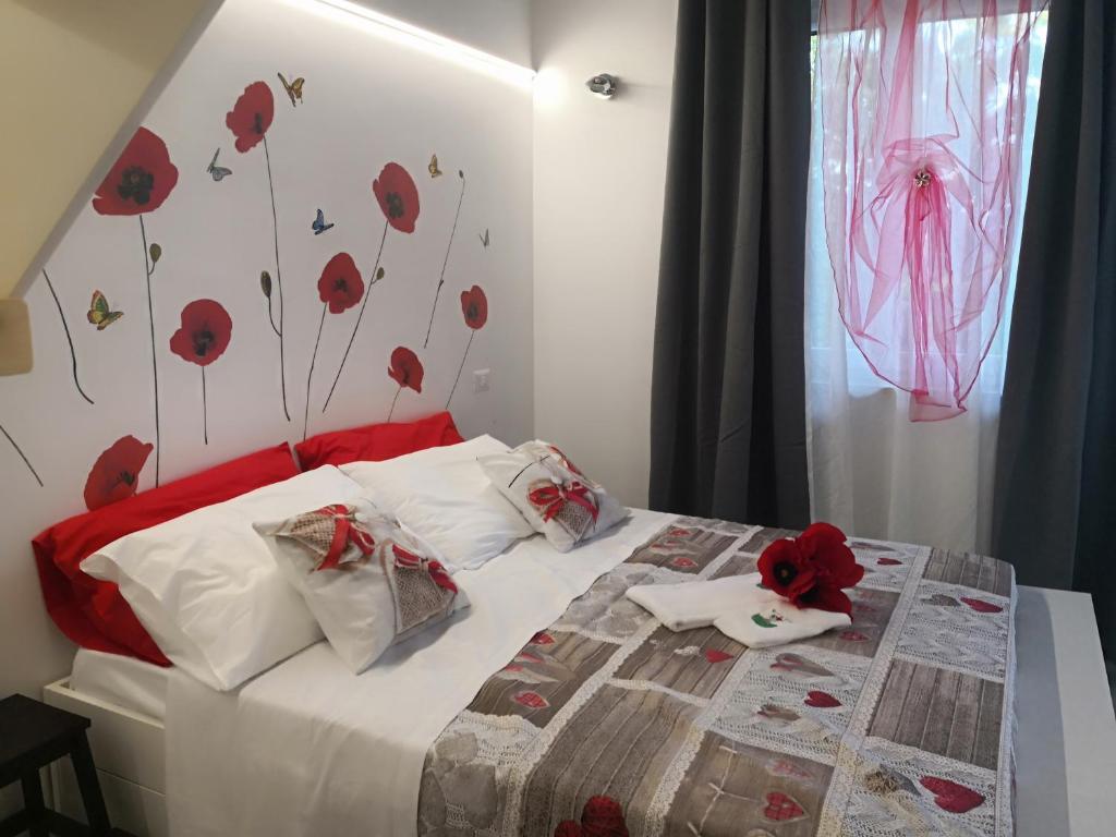 een slaapkamer met een bed met rode papavers aan de muur bij Marimà in Pollenza