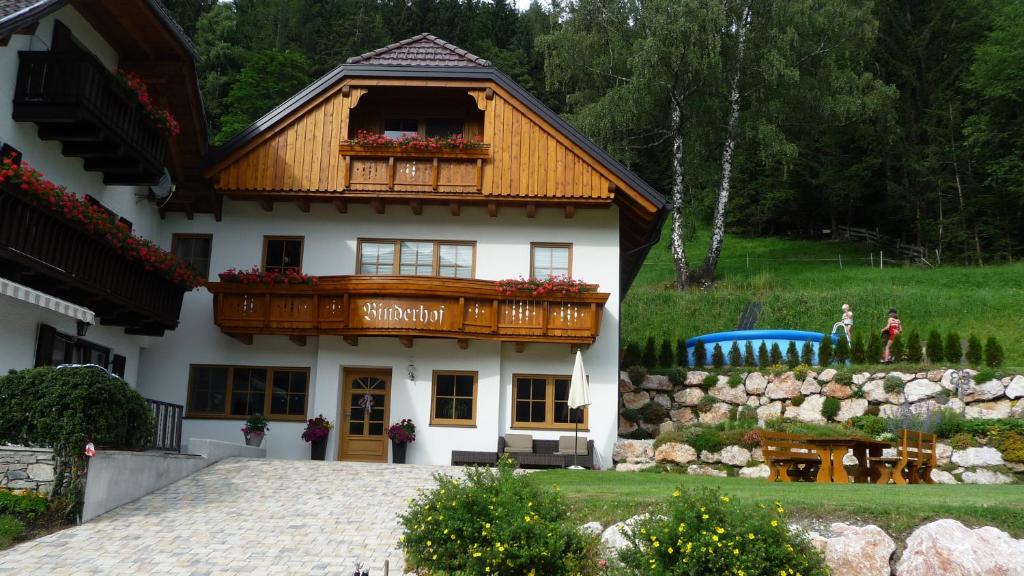 a house with a balcony on top of it at Binderhof in Weisspriach