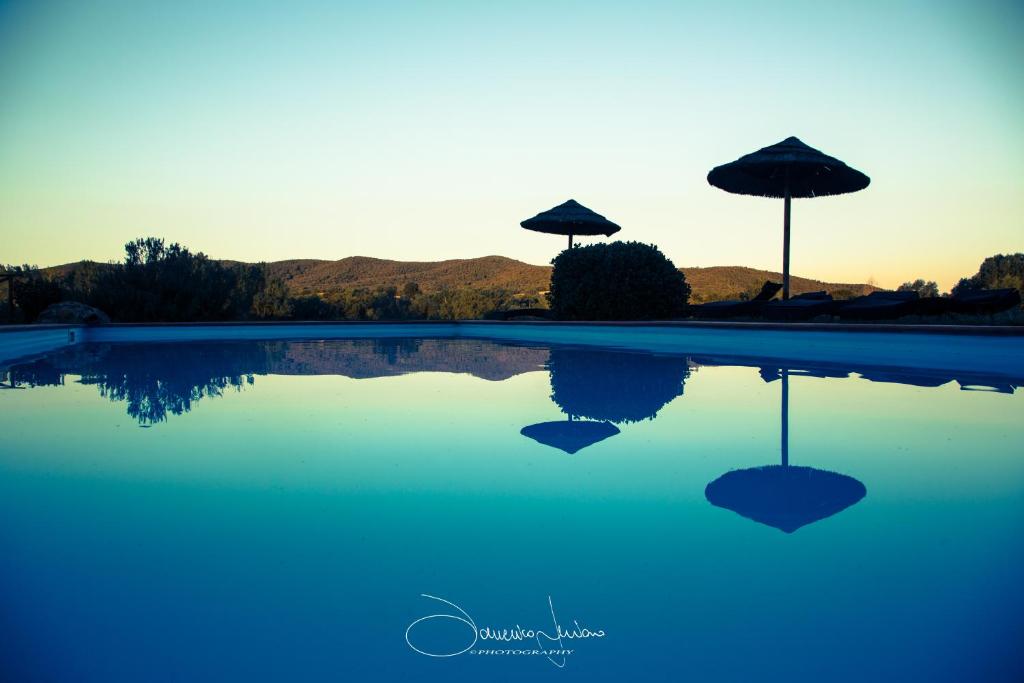 dos sombrillas sentadas en la parte superior de una piscina en Agriturismo Bonzalone en Montiano