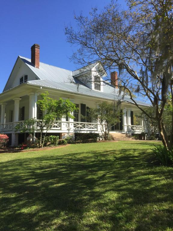 a white house with a lawn in front of it at Canemount Plantation Inn in Westside