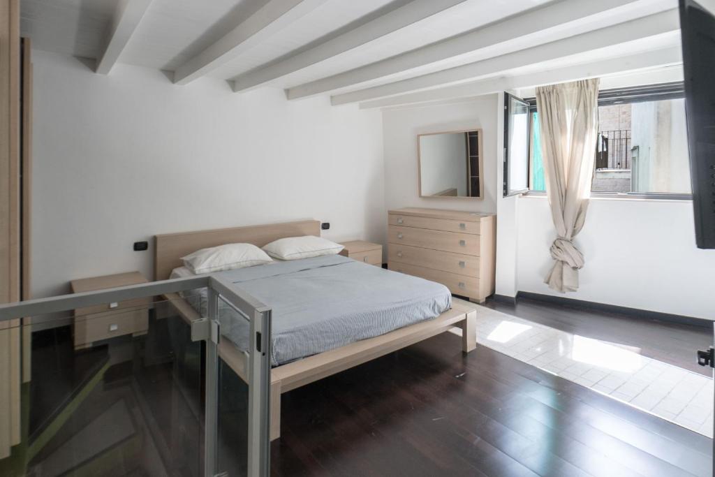 バーリにあるREM Apartment - Moscatelliのベッドルーム1室(ベッド1台、ドレッサー、窓付)