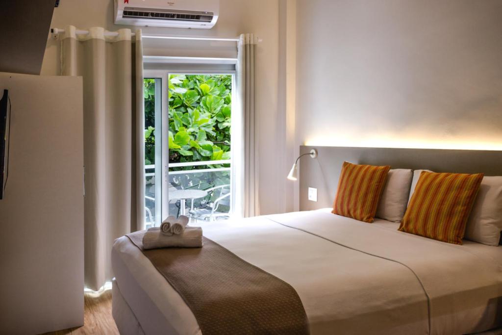 Injoy Lofts Ipanema في ريو دي جانيرو: غرفة نوم بسرير كبير ونافذة
