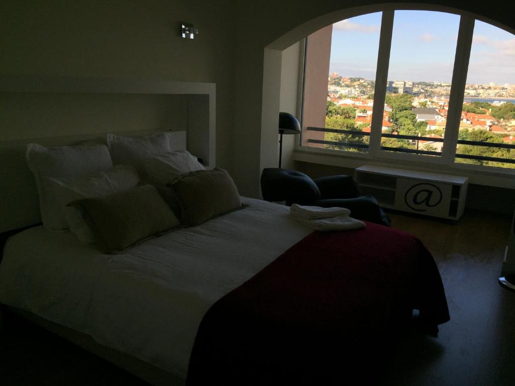 a bedroom with a large bed and a large window at Cascais Premium Sea View in Cascais