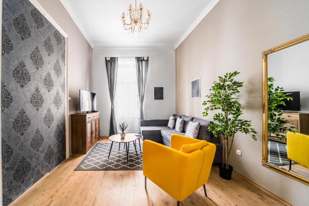 a living room with a couch and a yellow chair at Nyár 3 Bedroom Centre Entire Home in Budapest