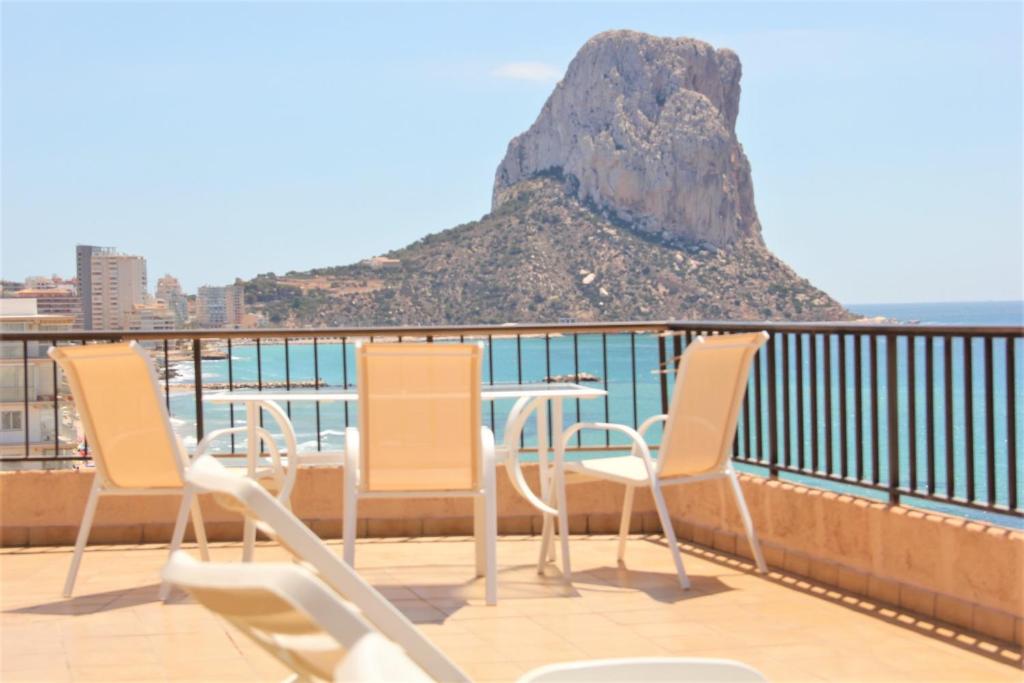 a table and chairs on a balcony with a mountain at Caribe in Calpe