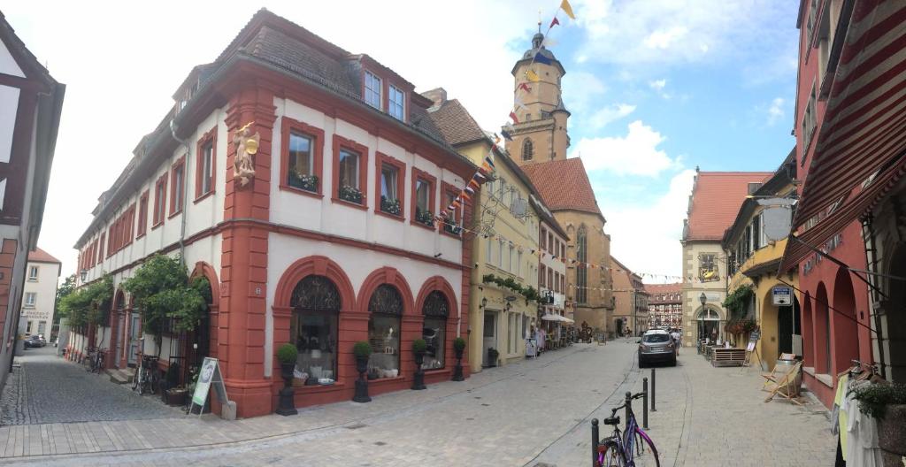 una calle de la ciudad con un edificio con una torre de reloj en Palais-Volkach, en Volkach