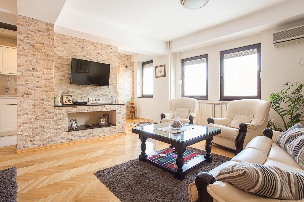 - un salon avec un canapé et une cheminée dans l'établissement Tina Apartments, à Skopje