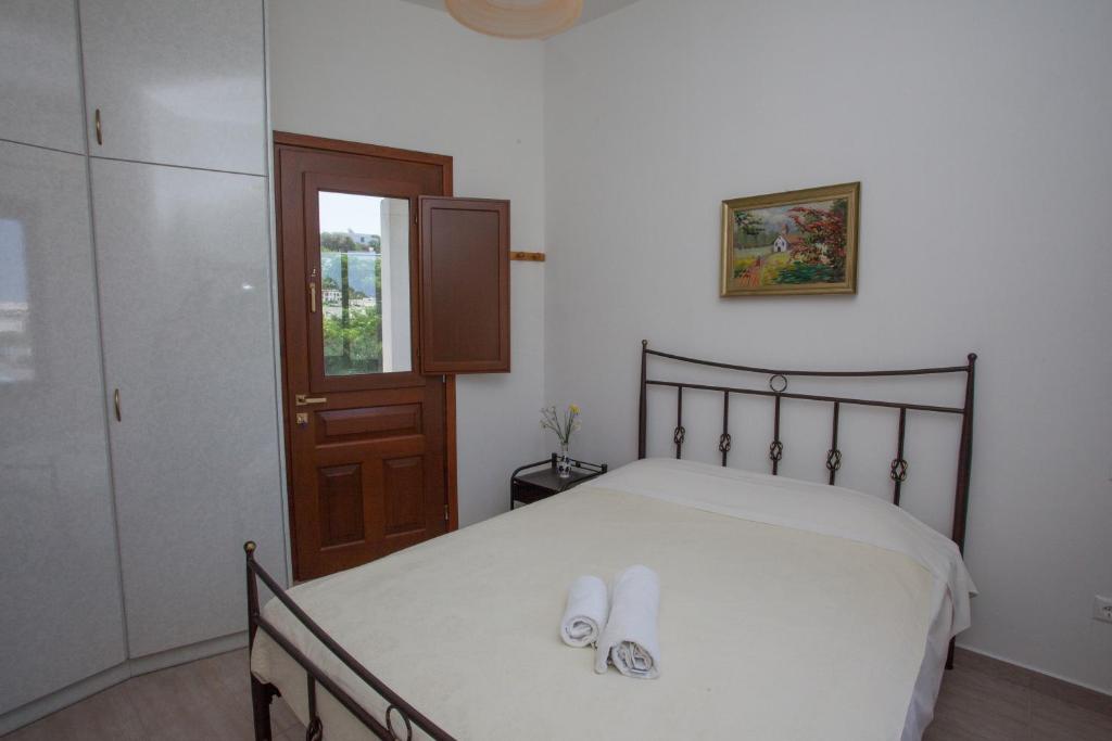 a bedroom with a bed with two slippers on it at Villa Zacharo in Skala