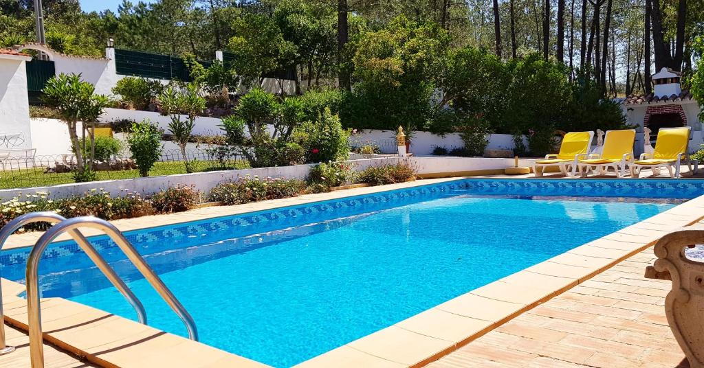 una piscina en un patio con tumbonas amarillas en Casa da Mae, en Salir